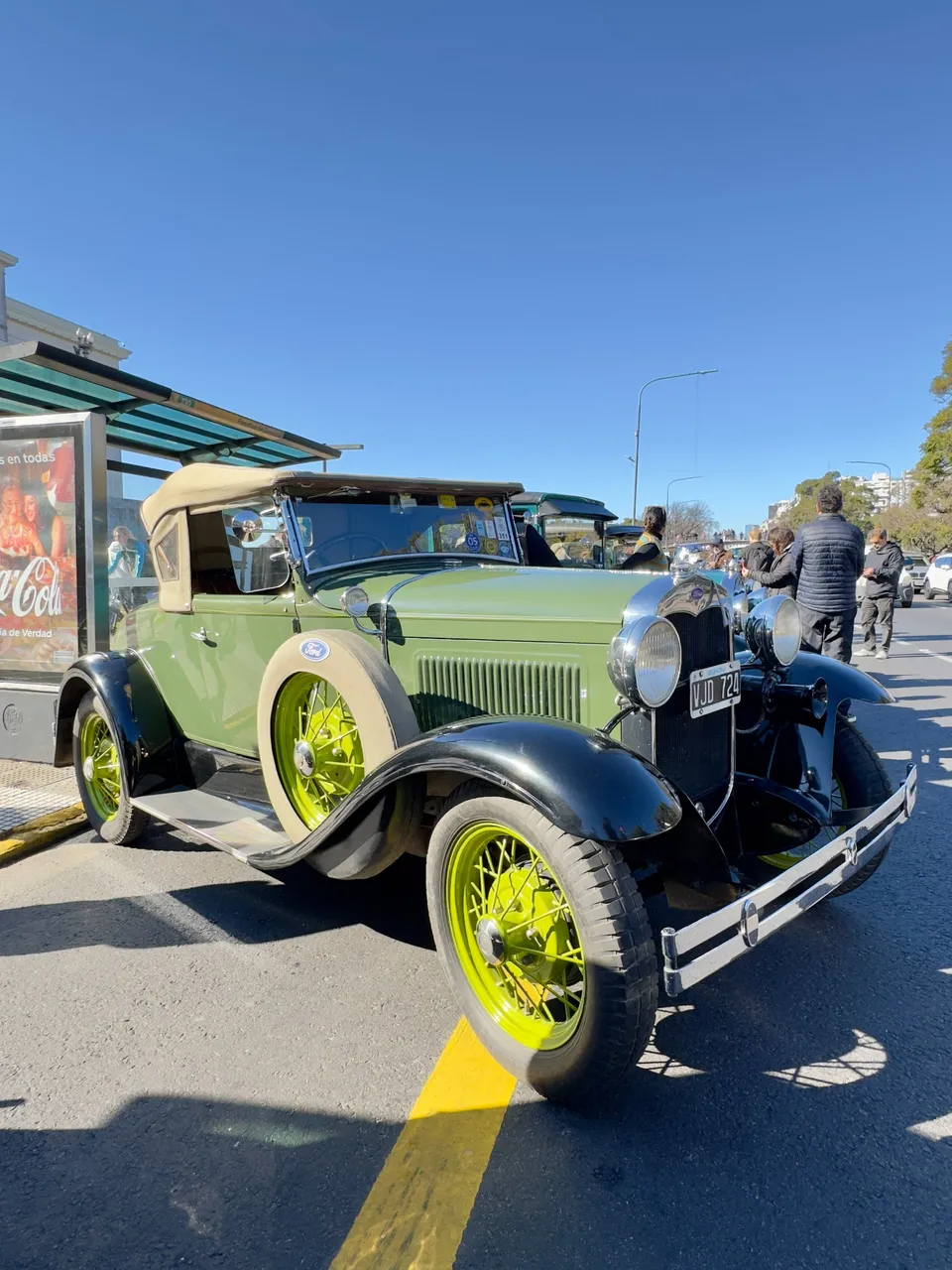 Ford A verde de los años treinta estacionado en la calle, con las ruedas de rayos amarillas