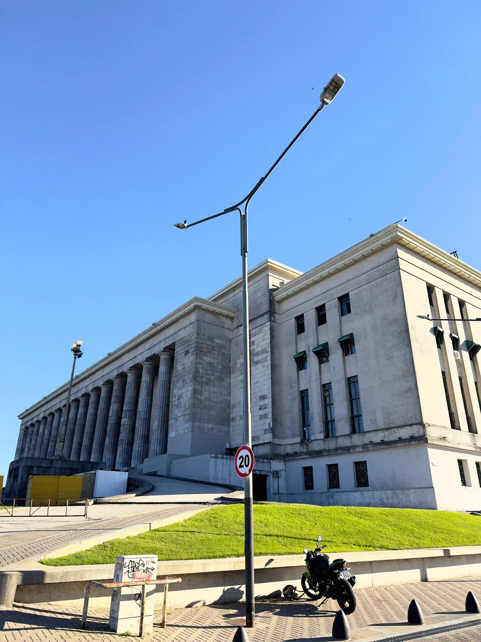 La columnata de la Facultad de Derecho contra el cielo azul, con una moto estacionada en primer plano