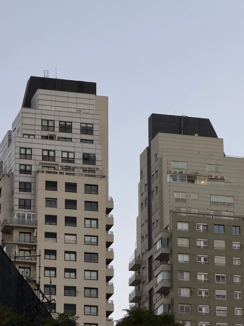 Dos torres de departamentos con la última luz de la tarde sobre las fachadas